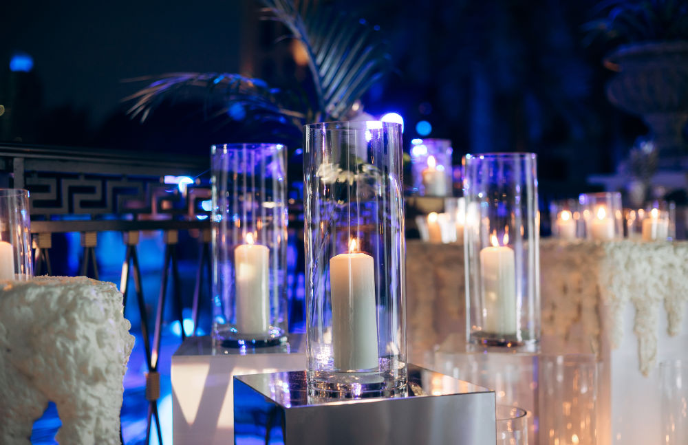 Elegant outdoor evening event with candles in glass holders, providing ambient lighting and a sophisticated atmosphere.