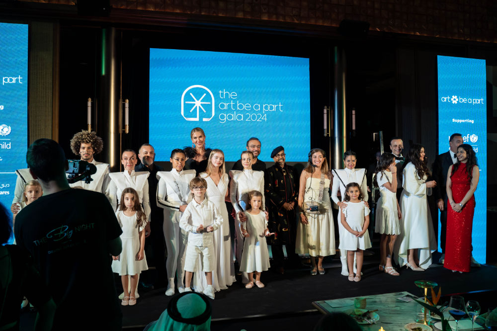 Group photo at Art be a Part Gala 2024 event, people in elegant attire, standing on stage.