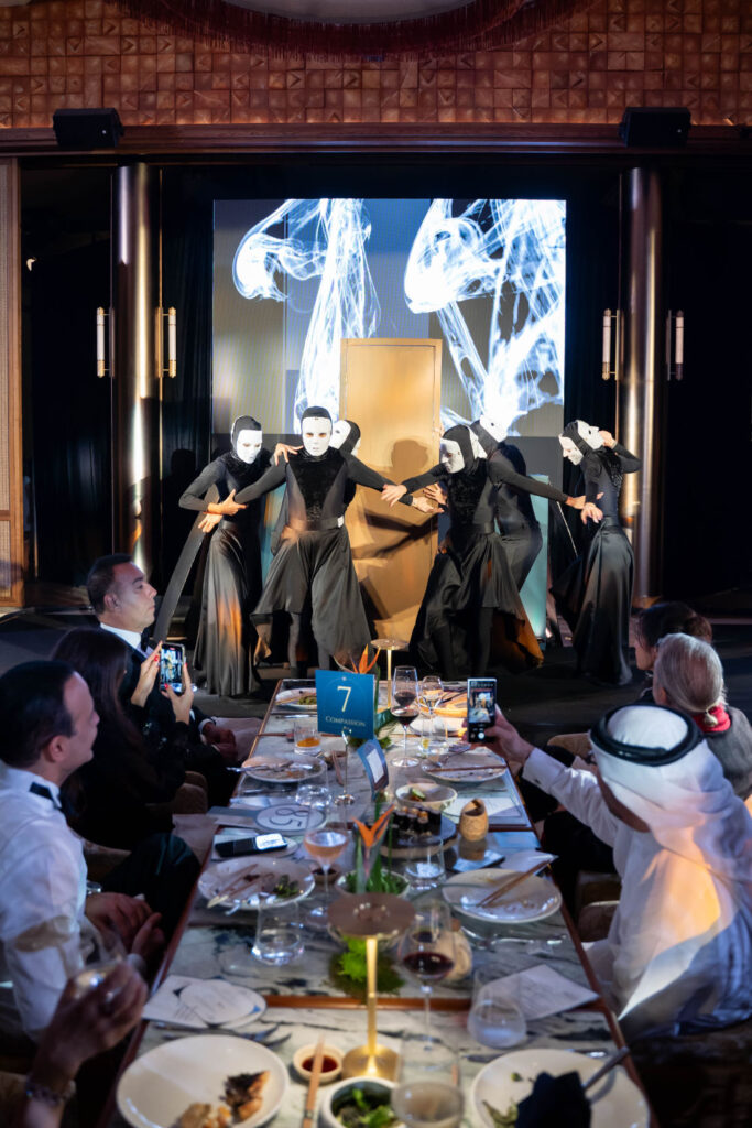 Masked performers entertain guests at an elegant dinner event, capturing the audience's attention.