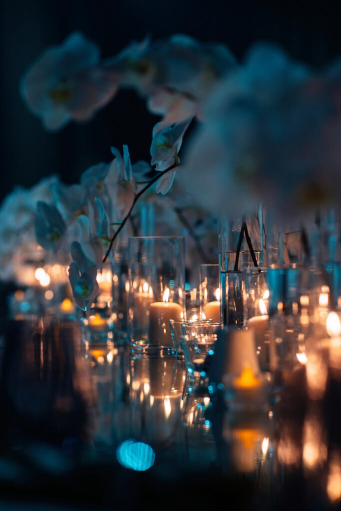 Elegant candlelit floral table arrangement, dimly lit for a romantic ambiance.