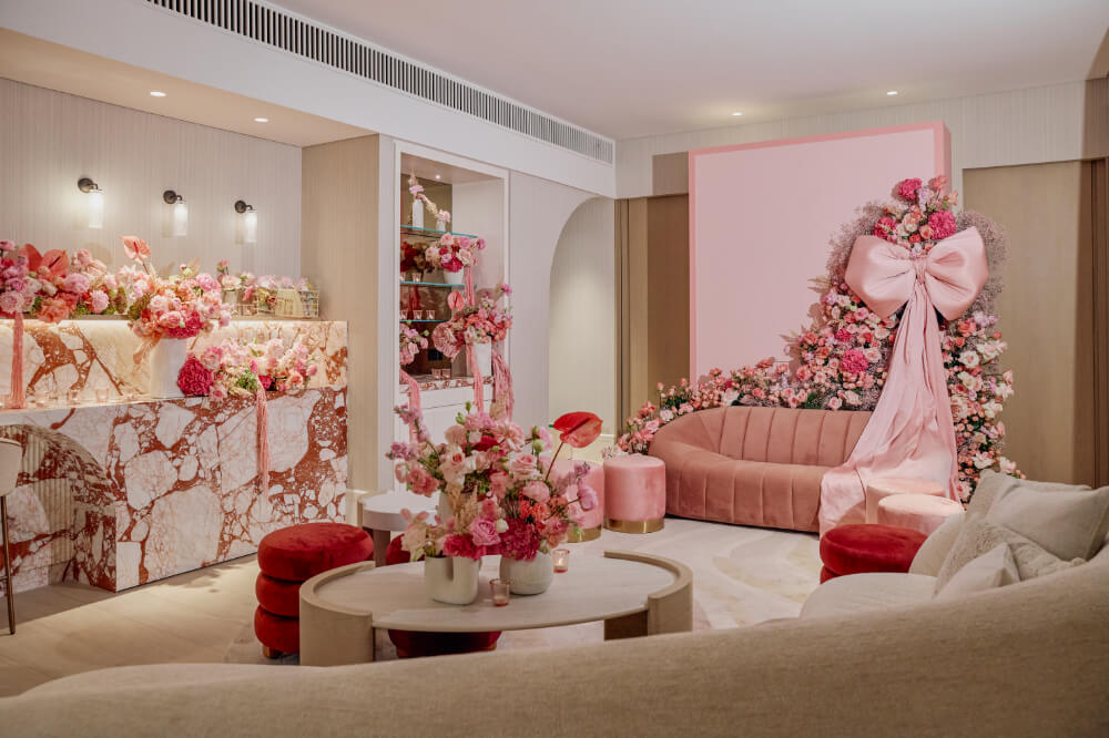 Luxurious pink-themed room with elegant floral decor, plush seating, marble accents, and soft ambient lighting.