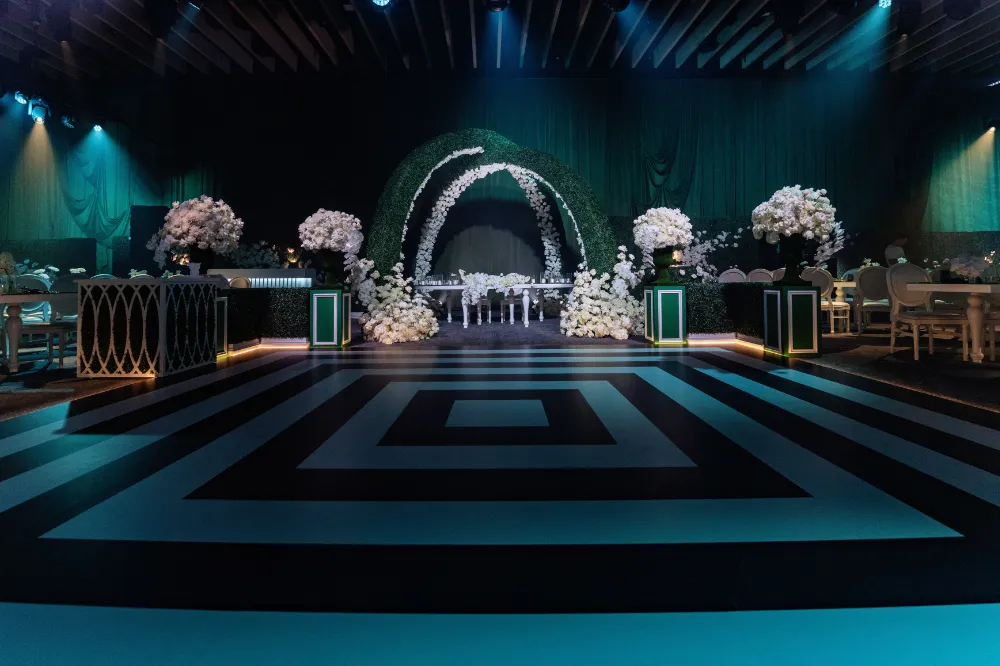 Luxurious wedding hall with elegant floral arrangements and geometric patterned flooring.