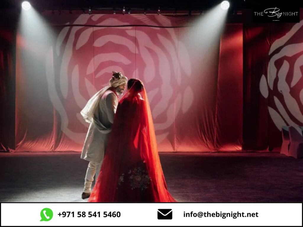 Couple sharing a moment under spotlight in a romantic setting with elegant red decor.