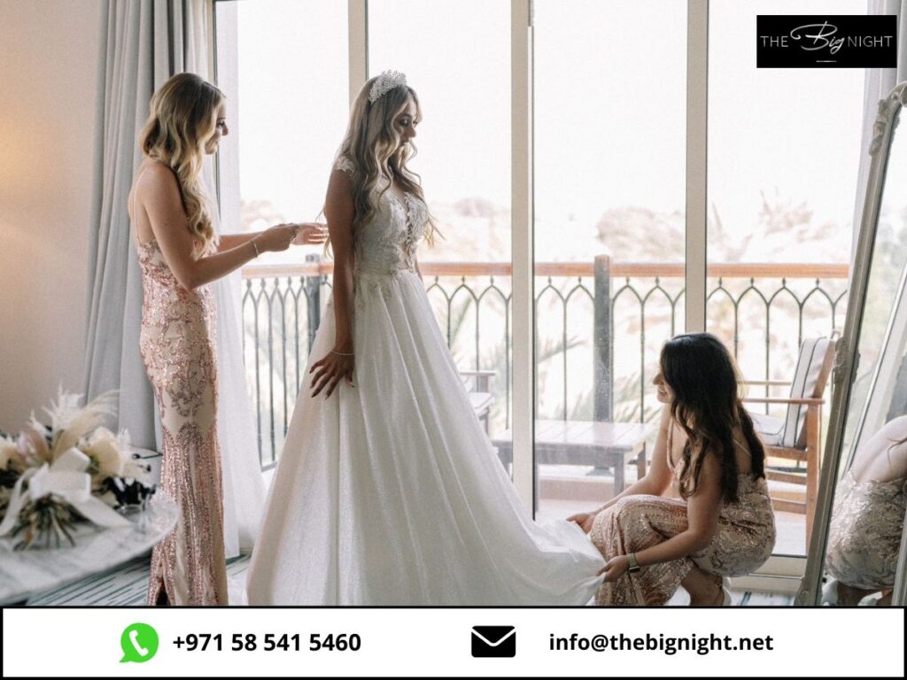 Bride prepares for her wedding day with bridesmaids assisting, dressed elegantly in a bright, airy room.
