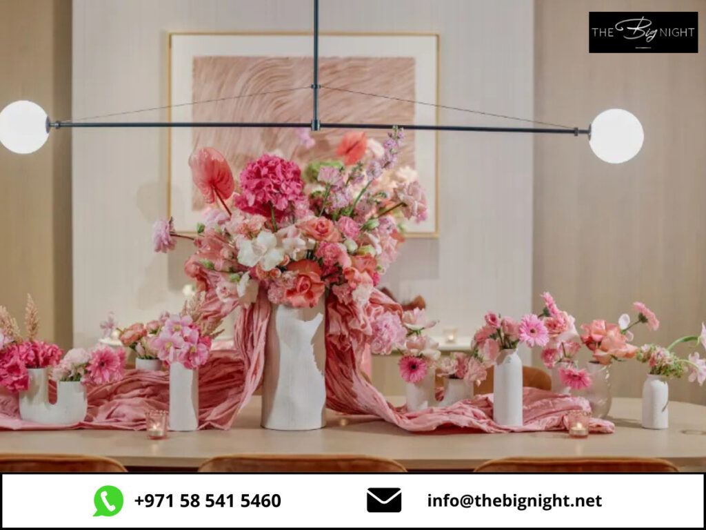 Elegant floral table centerpiece with pink flowers, perfect for events by The Big Night. Contact via info@staging.thebignight.net.