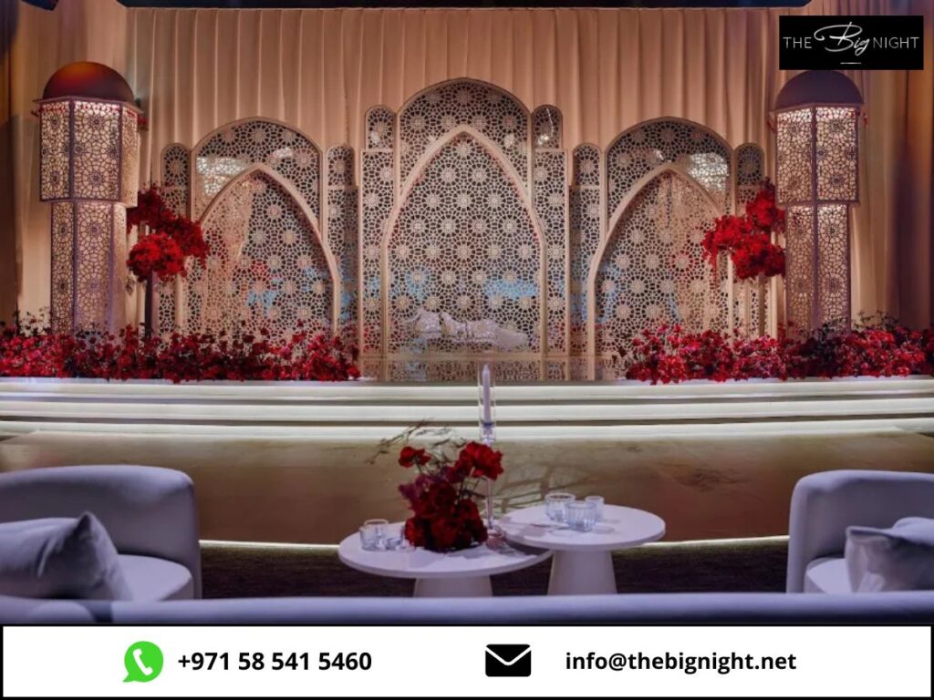 Elegant wedding stage with intricate patterns, red floral decor, and modern seating at The Big Night event.
