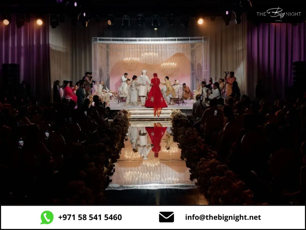 Elegant wedding ceremony with guests, a radiant couple under a chandelier, captured on a beautifully decorated stage.