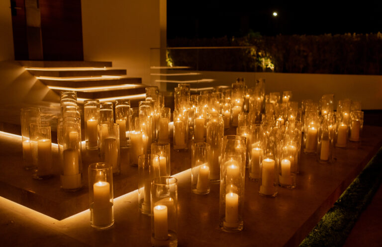 Glow of numerous candles in glass holders, illuminating steps at night, creating a warm and serene ambiance.