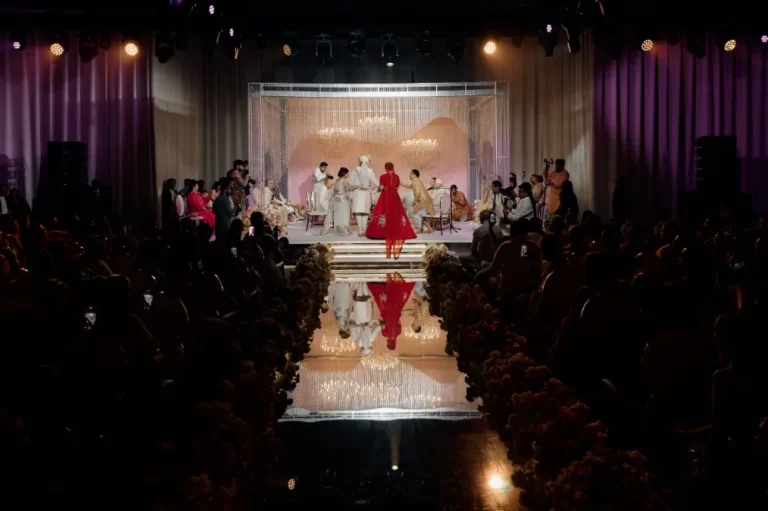 Elegant wedding ceremony with a bride in a stunning red dress walking down the aisle, surrounded by guests and lavish decor.